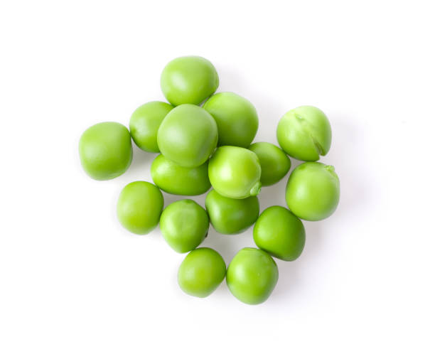 istock Fresh green peas seeds on a white background, top view 1215861099