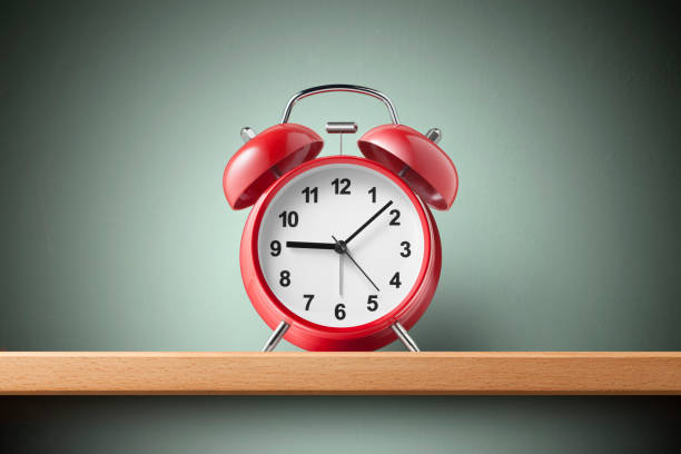istock Red alarm clock on the shelf 1215861960