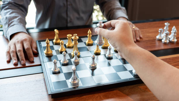 istock Business man take a king figure checkmate on the chess board game - strategy, management or leadership success concept 1215863763