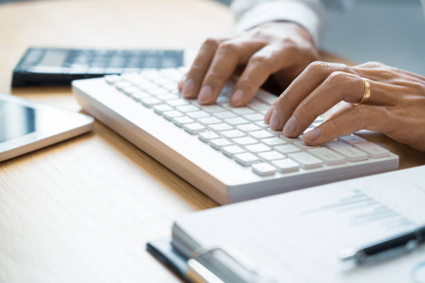 istock Close-up of male hands typing on keyboard Working On Compute Sitting Table And Office Tools At Workplace, writing emails, communicating online concept 1215863826