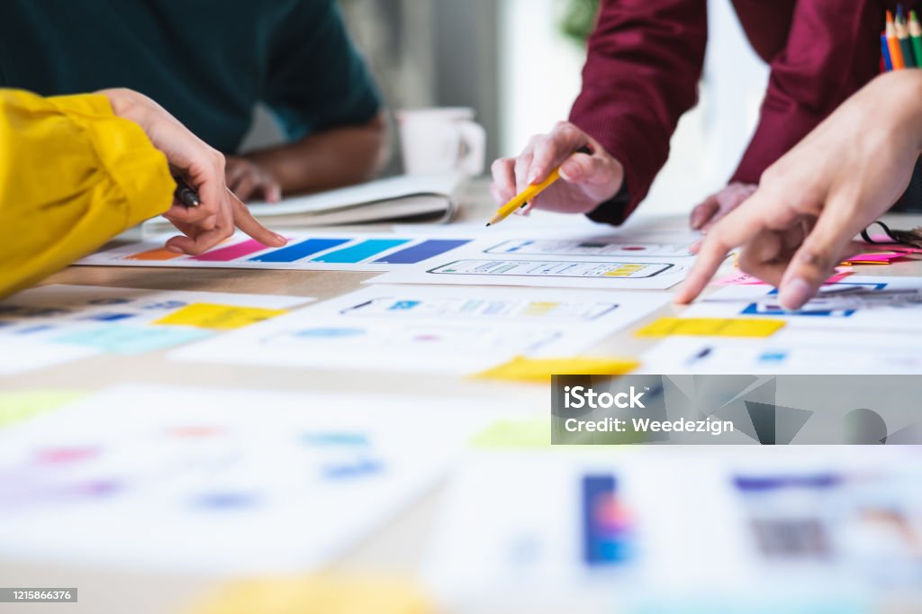 Close up ux developer and ui designer brainstorming about mobile app interface wireframe design on table with customer brief and color code at modern office.Creative digital development agency User Experience Stock Photo