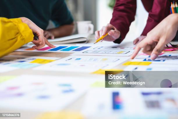 Close Up Ux Developer And Ui Designer Brainstorming About Mobile App Interface Wireframe Design On Table With Customer Brief And Color Code At Modern Officecreative Digital Development Agency Stock Photo - Download Image Now