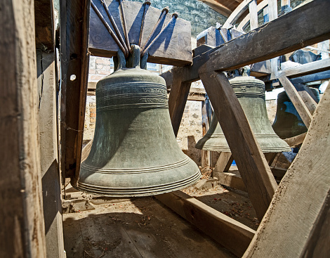 Traditional large old bells hanging in an english church tower from the middle ages