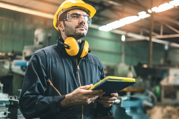 ingegneri industriali in hard hats.work presso la fabbrica di produzione di industria pesante.operaio industriale al chiuso in fabbrica. uomo che lavora in una fabbrica industriale. sicurezza primo concetto. - protective workwear foto e immagini stock