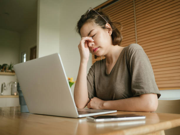 istock Asian woman struggling with using laptop at home. 1215867240