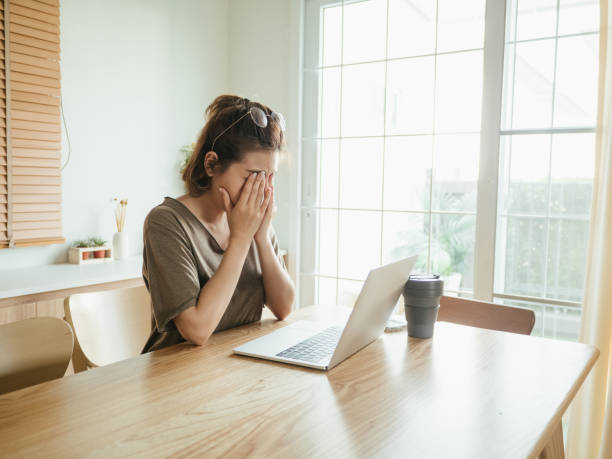 istock Asian woman struggling with using laptop at home. 1215867241