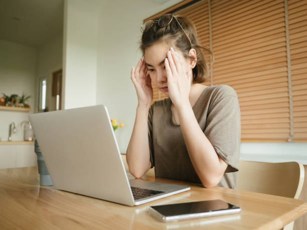 istock Asian woman struggling with using laptop at home. 1215867332