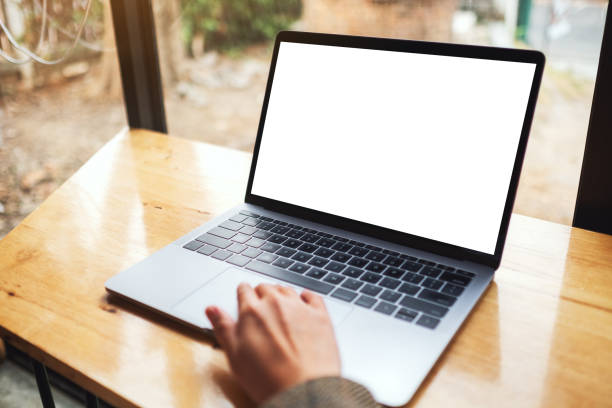istock a woman using and touching on laptop computer touchpad with blank white desktop screen on wooden table 1215867633