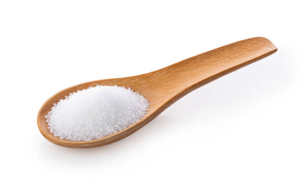istock sugar in wooden spoon on white background 1215867894