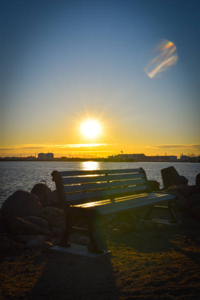 istock bench at sunrise by the water 1215868658
