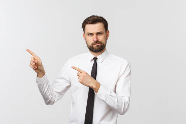 istock Bearded serious businessman pointing finger at you. Isolated on grey studio background 1215870295