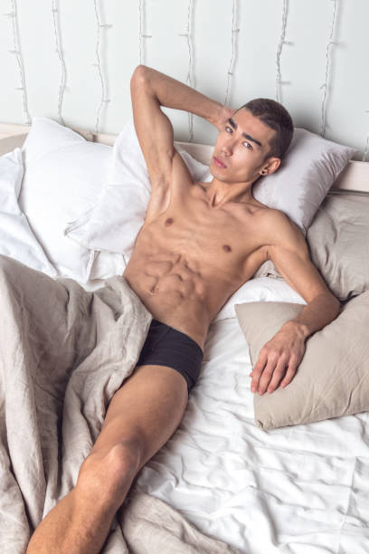 istock Young handsome man rest in bed. Sexy naked guy is resting 1215873016