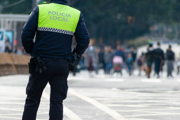 nahaufnahme eines polizisten mit "lokaler polizei" auf der uniform auf spanisch geschrieben - police power stock-fotos und bilder