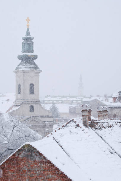 istock Spring snow and white roofs in old historic downtown 1215876012