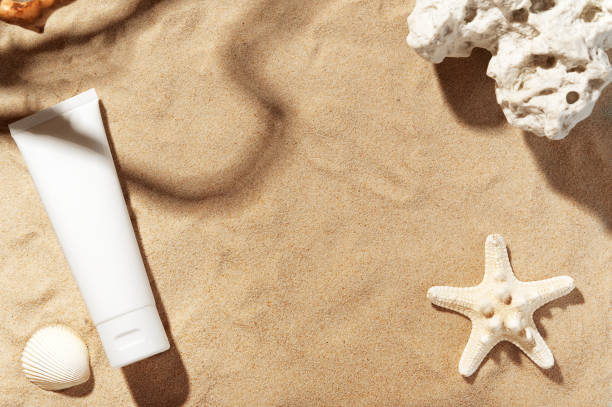 istock Unbranded body lotion tube with soft liquid. Summer decorations, sand backdrop. Mockup style. Copy space in centre. Skincare and professional cosmetology concept. 1215876280