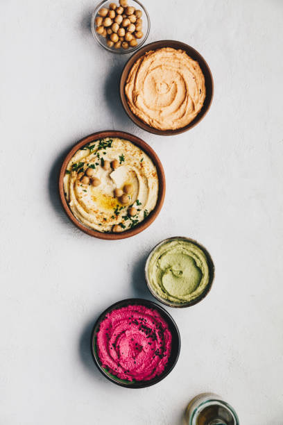 Flat-lay of Various Vegetarian dips hummus Flat-lay of Various Vegetarian dips hummus. Different kinds of dips. Traditional hummus, herbs hummus, beetroot hummus and lentils humus meze stock pictures, royalty-free photos & images