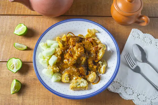 Photo of Delicious batagor or meatballs tofu is one of the popular indonesian traditional foods. Made from fish, tofu and peanut sauce. on wooden background