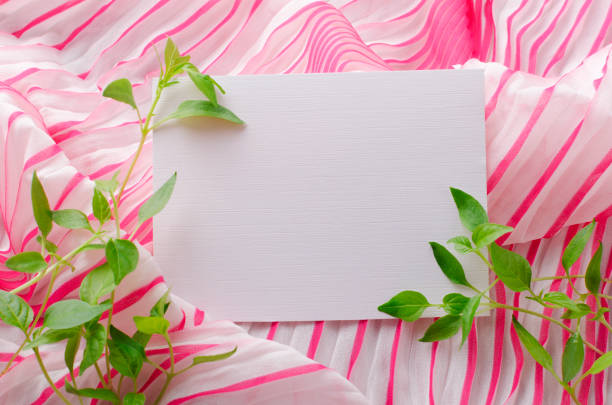 Beautiful fresh spring foliage, craft paper card on the pink soft texture.Concept of retail summer sales or invitation, greeting card