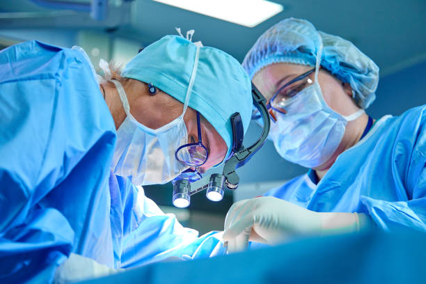 ein chirurgenteam in uniform führt eine operation an einem patienten in einer herzchirurgie-klinik durch. moderne medizin, ein professionelles team von chirurgen, gesundheit - chirurg stock-fotos und bilder