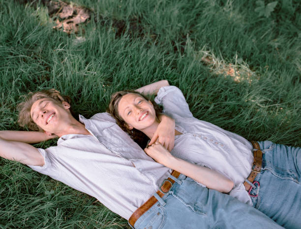 istock Smiling young couple lying in grass 1215883426