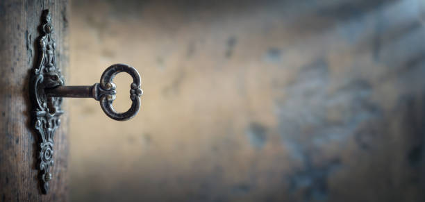 istock Old key in keyhole, macro shot. Gothic style. Key to knowledge. 1215883552