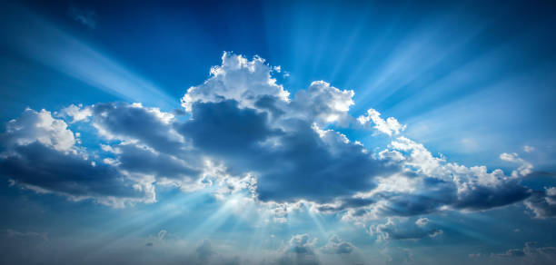 istock Bright sun shining in clouds on sky. 1215883596