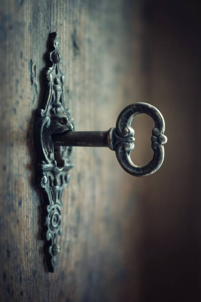istock Old key in keyhole, macro shot. Gothic style. Key to knowledge. 1215883700