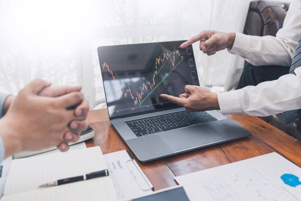 istock Working business man, team of broker or traders talking about forex on multiple computer screens of stock market invest trading financial graph charts data analysis. 1215884802