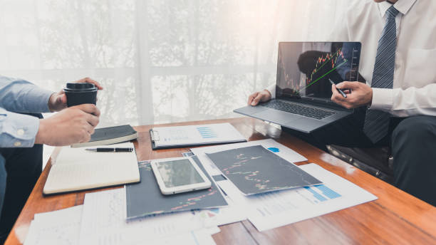 istock Working business man, team of broker or traders talking about forex on multiple computer screens of stock market invest trading financial graph charts data analysis. 1215884983