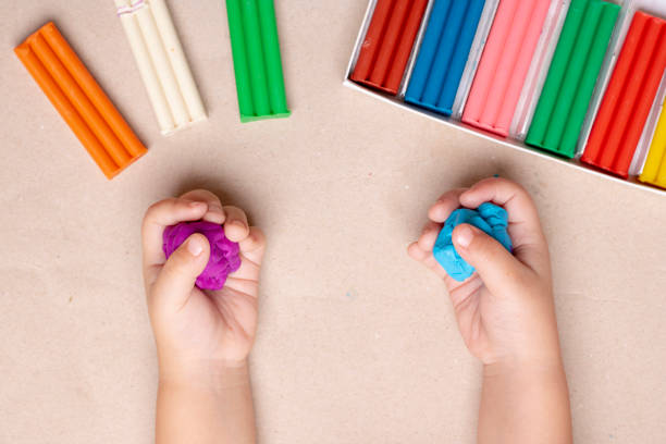 istock Child's hands with colorful clay, top view and copy space 1215887780