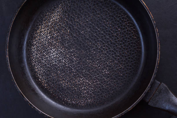 istock Top view of empty black pan on the black background 1215888697