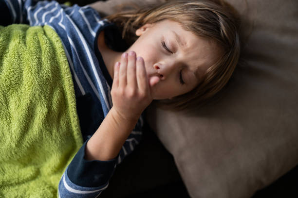 istock Little ill boy coughing while having a virus in bed at home. 1215890087