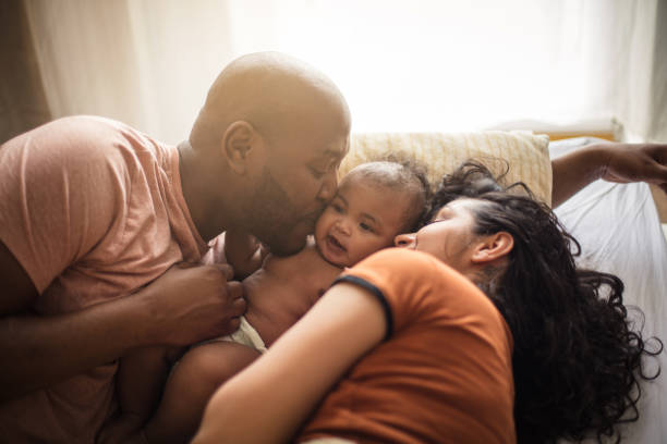 We stick together. We stick together. African American parents with daughter on bed. real life photos stock pictures, royalty-free photos & images