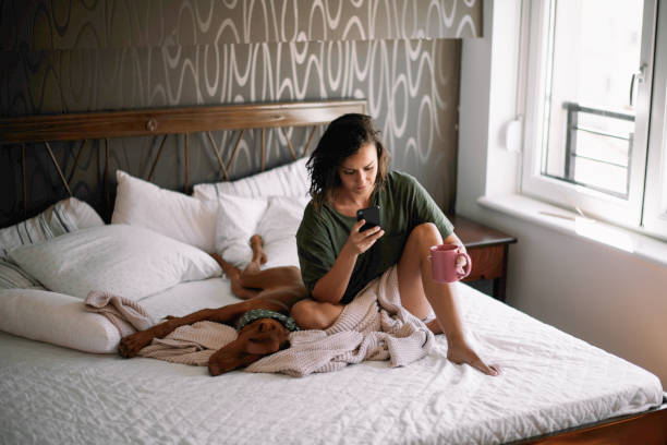 istock Beautiful woman lying on bed with her dog 1215892394