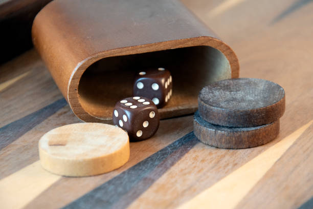 Brown backgammon dice and pieces on wooden board