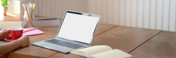 istock Cropped shot of university student holding coffee cup on wooden table while relaxing from doing homework 1215894146