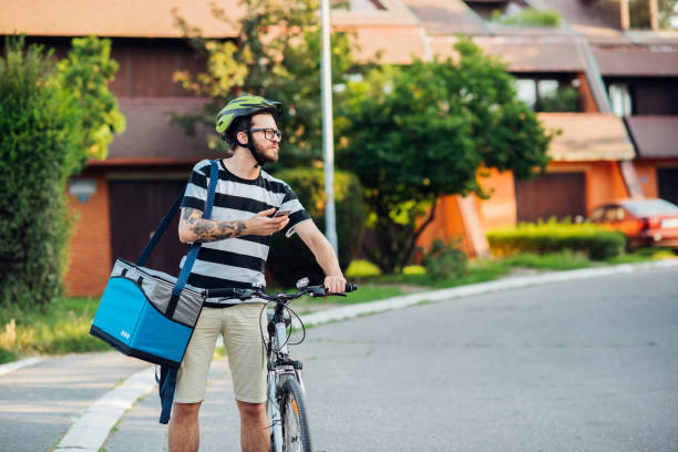 istock Delivery guy on a bike searching for the customer 1215895469