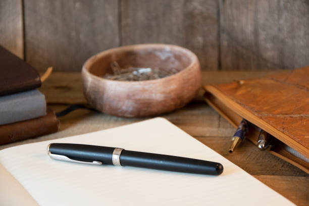 istock Open notebook, pen, pencil case and paperclips with wooden background 1215895732