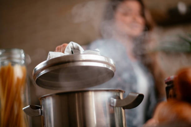 istock Young woman preparing food in kitchen 1215900774