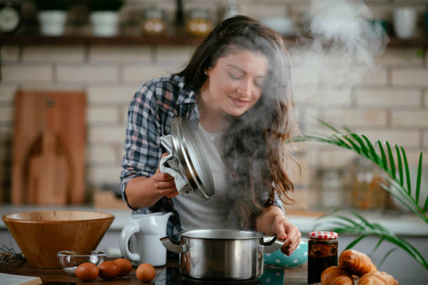 istock Young woman preparing food in kitchen 1215900784