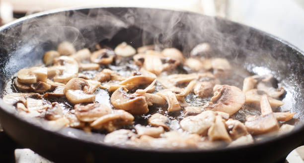 istock Fried mushrooms in a pan. Cooking mushrooms with steam emanating from them. 1215900990