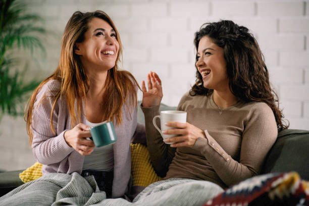 istock Best friends laughing on sofa. 1215901935