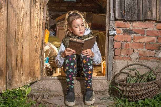 istock A girl reads a book in the barn. 1215902242