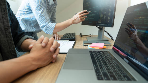 オフィスでコーディングする同僚の中央部 - hands clasped men table computer ストックフォトと画像