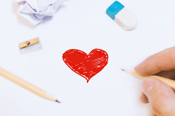 istock Close-Up Of Hand Drawing Heart Shape On Table 1215905223