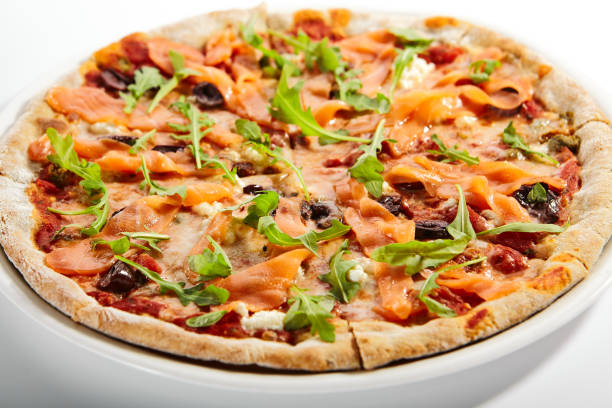 нарезанная пицца с лососем, оливками каламаты и вялеными помидорами - calamata olive стоковые фото и изображения