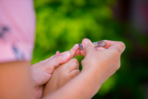 istock mother useing nail clipper  cutting  her kids nail 1215911316