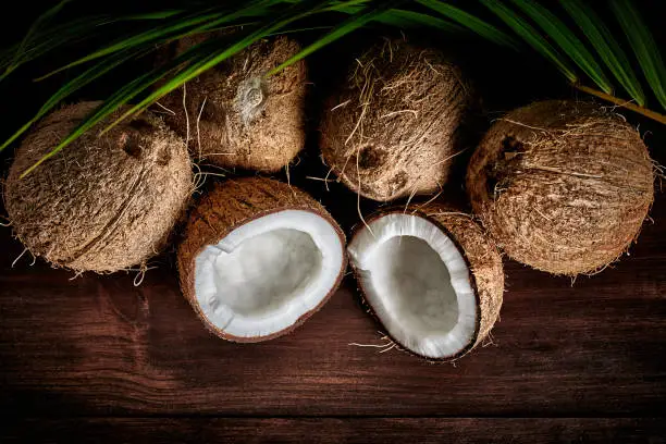 Photo of Low key of coconuts on wooden rustic table