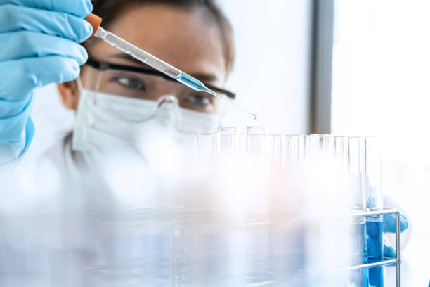 istock Biochemistry laboratory research, Chemist is analyzing sample in laboratory with equipment and science experiments glassware containing chemical liquid 1215916065