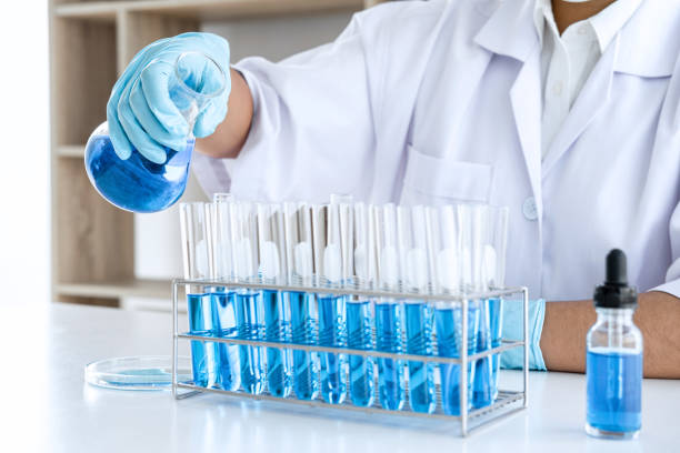 istock Biochemistry laboratory research, Chemist is analyzing sample in laboratory with equipment and science experiments glassware containing chemical liquid 1215916154